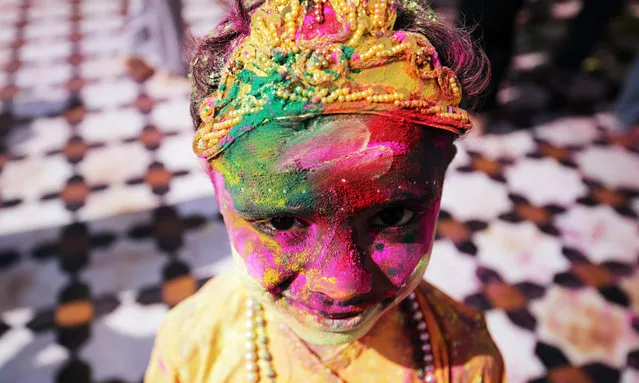 An Indian child smeared in colors and dressed as a Hindu God, Lord Krishna poses for a photograph during the Holi festival celebrations at Sri Laxmi Narayan Temple in Amritsar, India, 23 March 2016. Holi is celebrated at the end of the winter season on the last full moon day of the lunar month Phalguna (February or March) which usually falls in the later part of February or March and is celebrated by people throwing colored powder and colored water at each other. (Photo by Raminder Pal Singh/EPA)