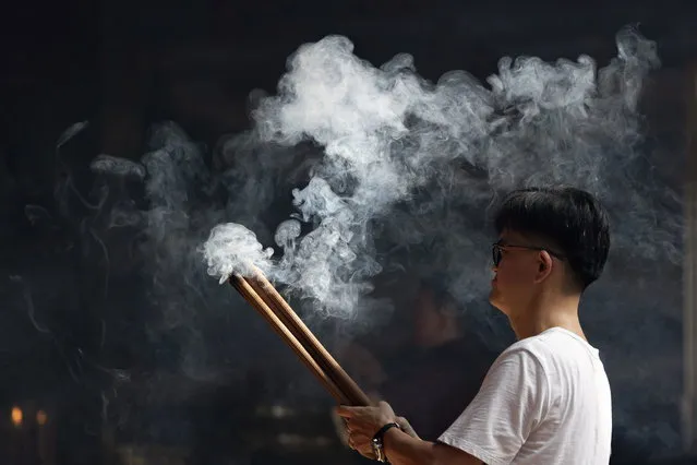 A man holds burning incense as he prays during Lunar New Year celebrations at a temple in Denpasar, Bali, Indonesia, 10 February 2024. The Chinese Lunar New Year, locally known as “Imlek”, falls on 10 February 2024, marking the start of the Year of the Dragon. (Photo by Made Nagi/EPA)