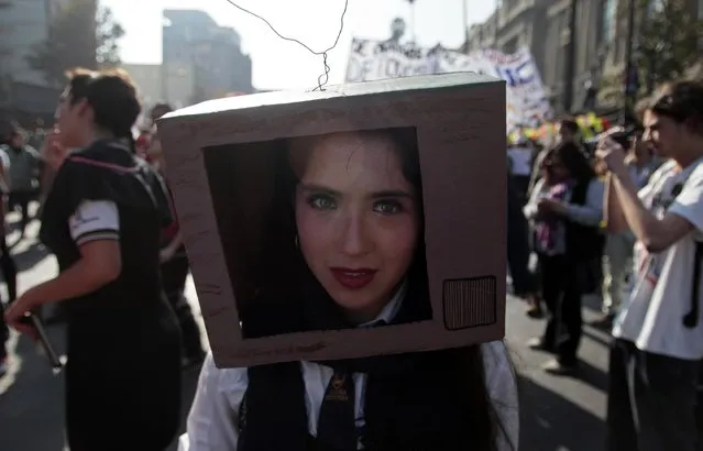 A demonstrator marches with a cardboard box on her  head during a march for free education, in Santiago, Chile, Thursday, May 14, 2015. (Photo by Luis Hidalgo/AP Photo)