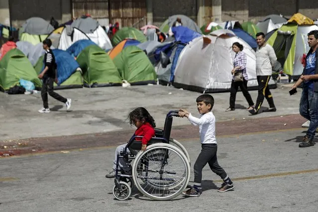 Children play with a wheelchair at a makeshift camp for refugees and migrants at the port of Piraeus, near Athens, Greece April 3, 2016. (Photo by Alkis Konstantinidis/Reuters)