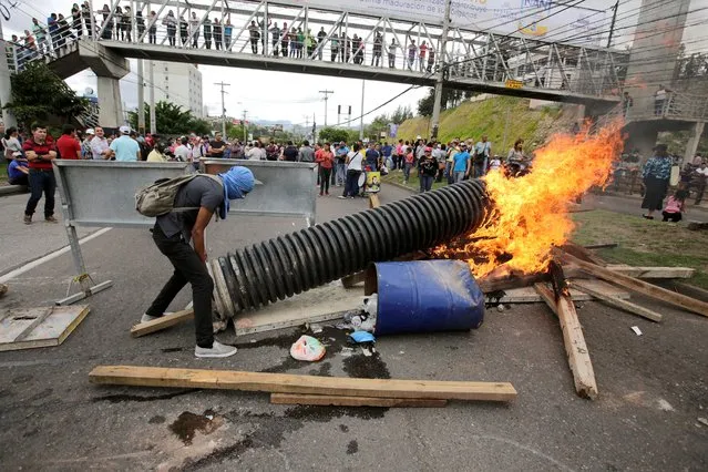 A demonstrator arranges a burning barricade during a protest against the government plans to privatize healthcare and education, in Tegucigalpa, Honduras on May 27, 2019. (Photo by Jorge Cabrera/Reuters)