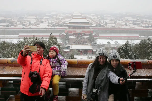 Visitors pose for pictures against the Forbidden City in Beijing, China, February 21, 2017. (Photo by Reuters/China Daily)