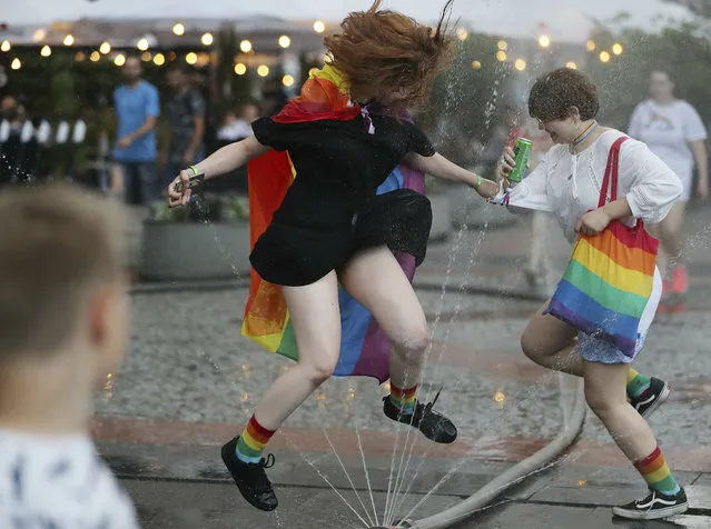 People take part in a gay pride parade in Warsaw, Poland, on Saturday, June 8, 2019. The Equality Parade is the largest gay pride parade in central and Eastern Europe. It brought thousands of people to the streets of Warsaw at a time when the LGBT rights movement in Poland is targeted by hate speeches and a government campaign depicting it as a threat to families and society. (Photo by Czarek Sokolowski/AP Photo)