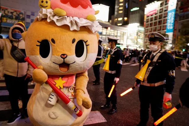 Reveller wearing a costume celebrates the New Year at Shibuya, although the countdown event was cancelled due to the coronavirus disease (COVID-19) pandemic, in Tokyo, Japan on December 31, 2021. (Photo by Androniki Christodoulou/Reuters)