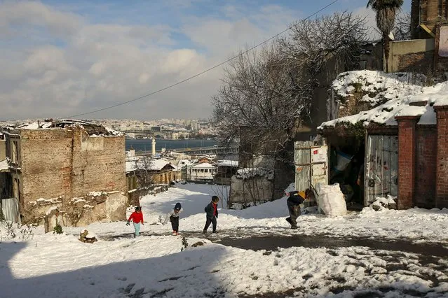 People walk in the snow at Istanbul, Monday, January 24, 2022. Snow blanketed most of Turkey's largest city Monday. Flurries are forecast to continue over the next few days in Istanbul, a metropolis of some 16 million spanning two continents and bridging Europe to Asia. (Photo by Emrah Gurel/AP Photo)