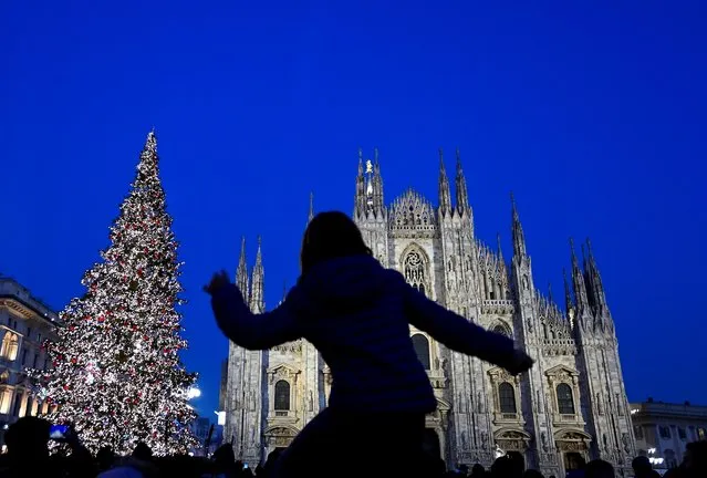 People admire a lit Christmas tree in Duomo Square in Milan, Italy, December 6, 2021. (Photo by Flavio Lo Scalzo/Reuters)