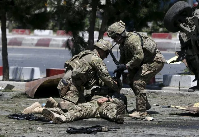 U.S. soldiers attend to a wounded soldier at the site of a blast in Kabul, Afghanistan June 30, 2015. (Photo by Omar Sobhani/Reuters)