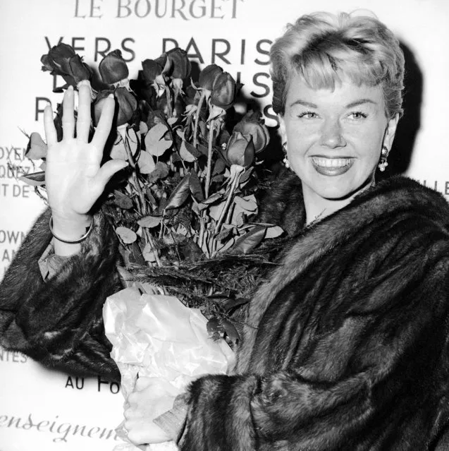 In this April 15, 1955 file photo, American actress and singer Doris Day holds a bouquet of roses at Le Bourget Airport in Paris, France after flying in from London. Day, whose wholesome screen presence stood for a time of innocence in '60s films, has died, her foundation says. She was 97. The Doris Day Animal Foundation confirmed Day died early Monday, May 13, 2019, at her Carmel Valley, California, home. (Photo by AP Photo/File)