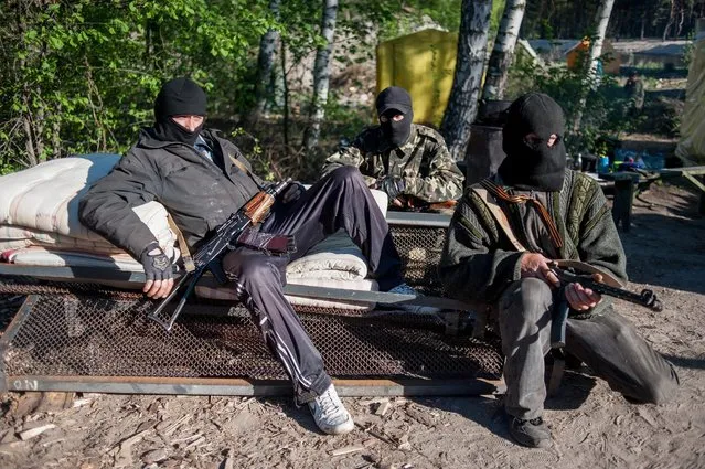 Armed pro-Russian protestors sit at a checkpoint near Krasnyi Liman, in the Donetsk area, Ukraine, 24 April 2014. At least five people were killed on 24 April in clashes between government forces and pro-Russian separatists in eastern Ukraine, prompting a warning by Russian President Vladimir Putin to the country's Western-backed interim leader. (Photo by Evgeniy Maloletka/EPA)