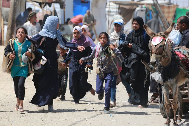 Palestinians rush during Israeli bombardment in the area in Rafah in the southern Gaza Strip on June 19, 2024, amid the ongoing conflict in the Palestinian territory between Israel and Hamas. (Photo by Bashar Taleb/AFP Photo)