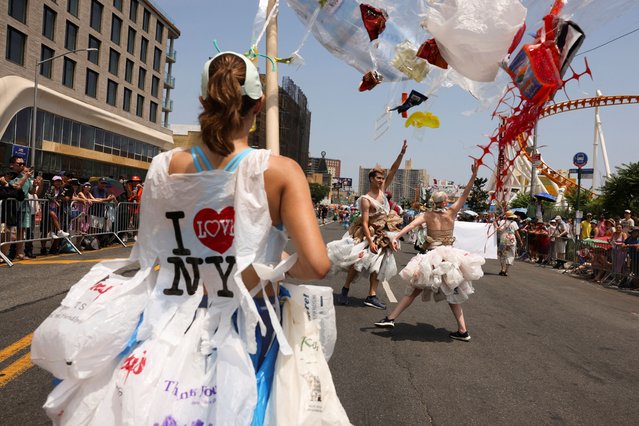 People raising awareness about plastic ocean pollution dance while participating in the Mermaid Parade during a heatwave in Coney Island, Brookly, New York City, U.S., June 22, 2024. (Photo by Caitlin Ochs/Reuters)