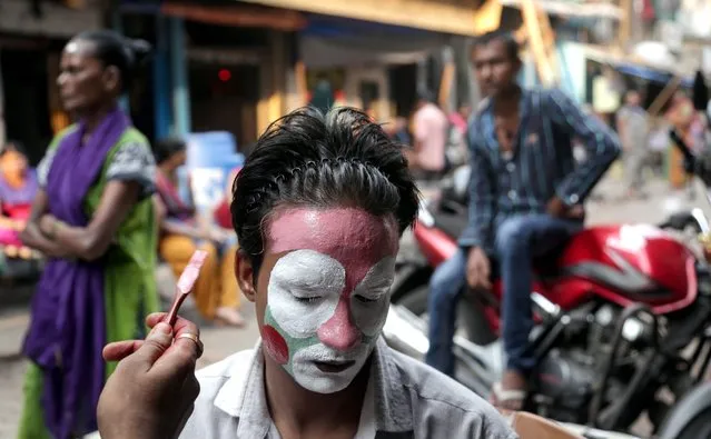 A picture made available on 12 May shows Altaf Ahmed, 28, physically challenged, gets ready to entertain people by turning himself into a Joker (Clown), in Mumbai, India, 11 May 2016. Altaf earns around 6 USD per day (INR 400) with his activity entertaining people and posing for photographs in the streets of Mumbai. (Photo by Divyakant Solanki/EPA)