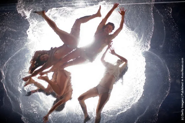 Artists preform on a pool suspended above the audience during the Fuerza Bruta dress rehearsal