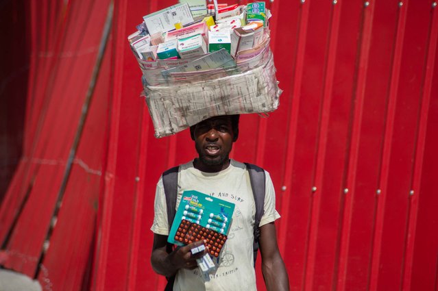 A street vendor carries medicines for sale in a street in Port Au Prince on June 13, 2024. Haiti's Prime Minister Garry Conille said June 12, 2024, that greater security and a crackdown on corruption would be priorities for his newly installed government in the troubled Caribbean nation. (Photo by Clarens Siffroy/AFP Photo)