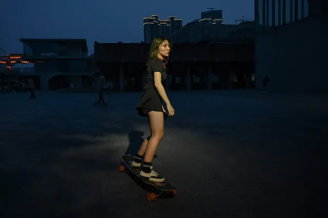 This photo taken on July 14, 2019 shows a young woman on a longboard at a park in Shanghai. Skateboarding will make its Olympic debut in Tokyo at the 2020 Olympic Games, but many in the growing scene in Shanghai complain that they have few places to go and are looked down upon as trouble-makers. (Photo by Hector Retamal/AFP Photo)