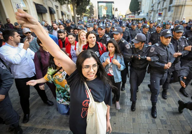 An activist shouts in front of law enforcement officers during a protest against domestic violence and violence against women in Baku, Azerbaijan on October 20, 2019. (Photo by Aziz Karimov/Reuters)
