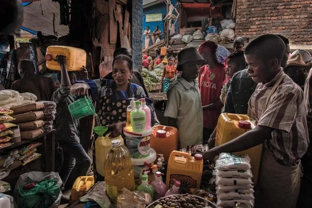 Vendors selling basic necessities tends to customers at Nyawera market in Bukavu, eastern Democratic Republic of Congo, on March 16, 2022. Congolese households, three-quarters of whom live below the poverty line, are worried about the economic consequences of the war led by Russia in Ukraine In Bukavu, for example, in one of the eastern provinces of the Democratic Republic of the Congo affected for more than 25 years by violence by armed groups, there is a strong fear that a devastating social crisis will add to the problems of insecurity. (Photo by Guerchom Ndebo/AFP Photo)