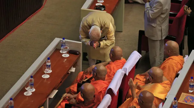 Indian Prime Minister Narendra Modi greets Sri Lankan Buddhist monks during the UN celebration of Vesak ceremony in Colombo, Sri Lanka, Friday, May 12, 2017. During his two-day visit Modi participated in the United Nations celebration of Vesak or the day of birth, enlightenment and death of the Buddha. He also inaugurated a modern hospital for the benefit of tea plantation workers , ancestors of Indian laborers brought by the British from the 18th century. (Photo by Eranga Jayawardena/AP Photo)