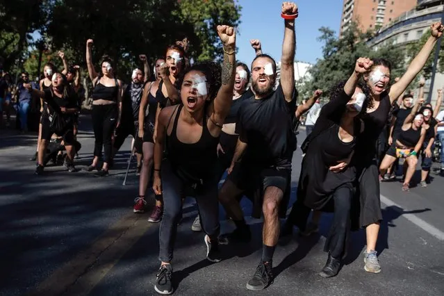 Demonstrators perform during a protest against the government's economic policies in Santiago on November 6, 2019. Chile's president said Wednesday his government had “nothing to hide” concerning allegations that police killed, tortured and sexually assaulted civilians during deadly protests against him as protesters called on demonstrators to expand their rallies to rich districts so far untouched by the wave of demonstrations, centering on a major shopping center. (Photo by Javier Torres/AFP Photo)