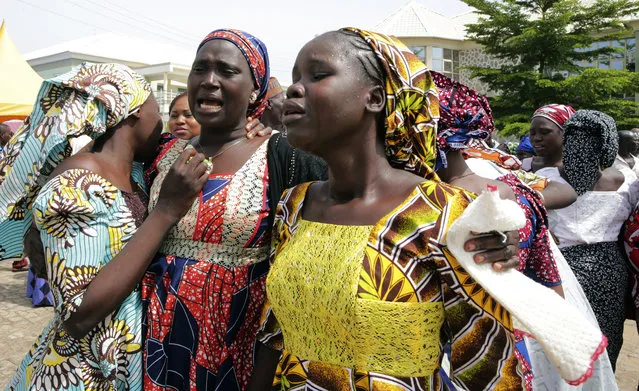 In this photo released by the Nigeria State House, Family members react as they embrace a relative, one of the released kidnapped schoolgirls, in Abuja, Nigeria, Saturday, May 20, 2017. ﻿The 82 Nigerian schoolgirls recently released after more than three years in Boko Haram captivity reunited with their families for the first time Saturday, as anxious parents looked for signs of how deeply the extremists had changed their daughters' lives. (Photo by Sunday Aghaeze/Nigeria State House via AP Photo)