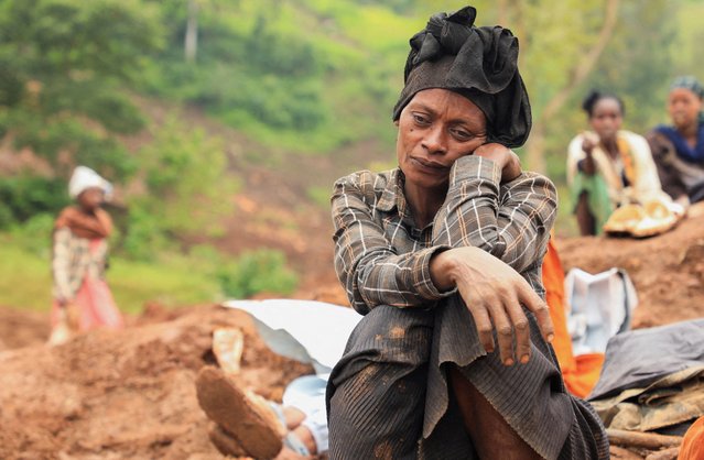 Zeritu Zekarias, 43, sits on the ground as her husband and relatives dig in search of the missing son at the site of the twin landslides last week, following heavy rains, that buried people in Gofa zone, Geze District of Southern Ethiopia on July 29, 2024. (Photo by Kumerra Gemechu/Reuters)