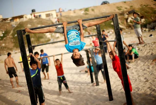 A Palestinian boy from Bar Palestine team demonstrates his street workout skills during a training session on a beach in Gaza City, June 3, 2016. (Photo by Mohammed Salem/Reuters)