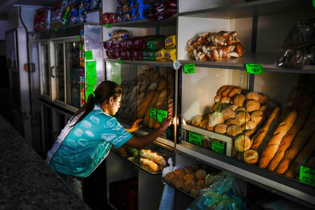 A bakery worker adjusts the shop during a blackout in Caracas, Venezuela, Friday, August 30, 2024. (Photo by Ariana Cubillos/AP Photo)