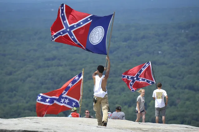 Confederate flag supporters demonstrate atop Stone Mountain as they protest what they believe is an attack on their Southern heritage during a rally at Stone Mountain Park in Stone Mountain, Ga., on Saturday, August 1, 2015. (Photo by John Amis/Atlanta Journal-Constitution via AP Photo)