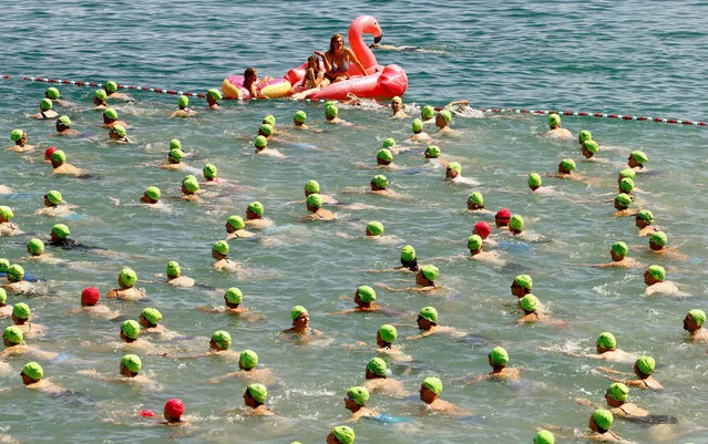 People participate in the annual public Lake Zurich crossing swimming event in Zurich, Switzerland July 5, 2017. (Photo by Arnd Wiegmann/Reuters)