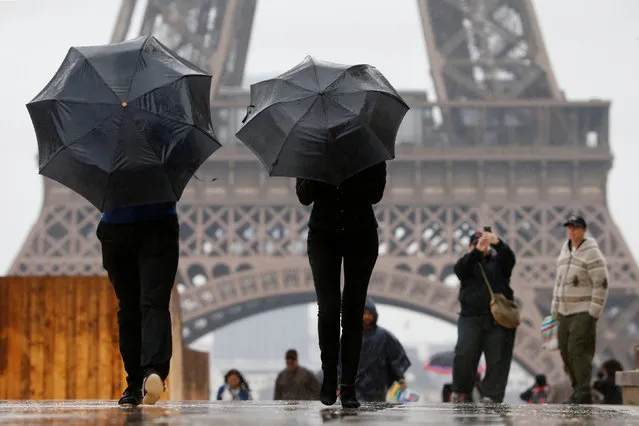 Tourists stroll on the Trocadero square, in front of the Eiffel Tower during a rainy day in Paris, France, May 30, 2016. (Photo by Charles Platiau/Reuters)