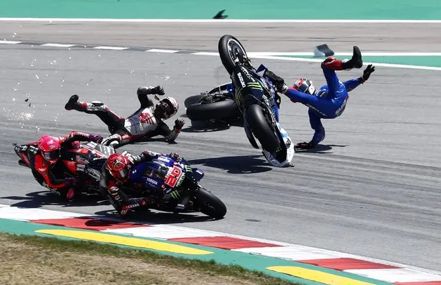 Spain's rider Alex Rins of the Team SUZUKI ECSTAR, top right, and Japan's rider Takaaki Nakagami of the LCR Honda IDEMITSU fall down during the MotoGP race of the Catalunya Motorcycle Grand Prix at the Catalunya racetrack in Montmelo, just outside of Barcelona, Spain, Sunday, June 5, 2022. (Photo by Joan Monfort/AP Photo)