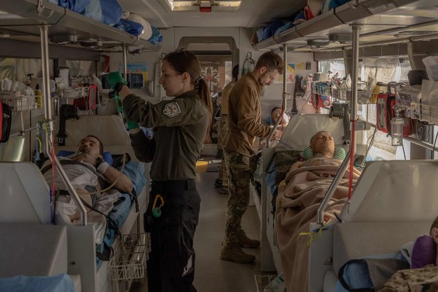 Paramedics of the volunteer medical battalion Hospitallers treat Ukrainian servicemen wounded in fighting in the Donetsk region on a medical evacuation bus driving to a hospital, on October 6, 2024, amid the Russian invasion of Ukraine. The medical evacuation bus called “Austrian” was named after the call sign of the Ukrainian doctor Natalia Frauscher who lived in Austria and died in a traffic accident during her duty on the previous Hospitallers's medical evacuation bus in June 2022. (Photo by Roman Pilipey/AFP Photo)