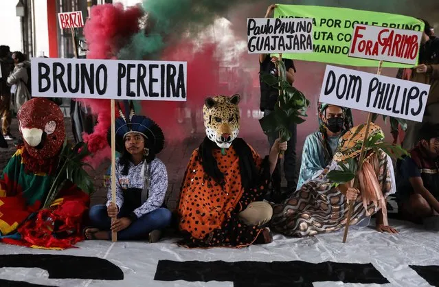 Demonstrators wearing animal costumes hold signs during a protest organized by Guarani indigenous people and environmental activists to demand justice for assassinated British journalist Dom Phillips and indigenous activist Bruno Pereira on June 18, 2022 in Sao Paulo, Brazil. After 11 days of search, police discovered human remains after a suspect confessed to the killing of Phillips and Pereira who went missing on June 05 in the Javari Valley, in the Amazon rainforest, near the border with Peru. Federal Police said on June 17 they have identified the remains of Phillips. (Photo by Rodrigo Paiva/Getty Images)