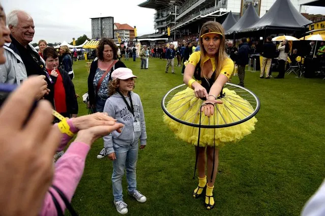 A woman performs at the departure village in York, prior to the beginning of the 201 km second stage of the 101st edition of the Tour de France cycling race on July 6, 2014 between York and Sheffield, northern England. (Photo by Eric Feferberg/AFP Photo)