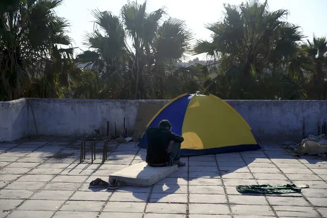 A migrant from Afghanistan sits at the terrace of a deserted hotel on the Greek island of Kos, August 13, 2015. (Photo by Alkis Konstantinidis/Reuters)