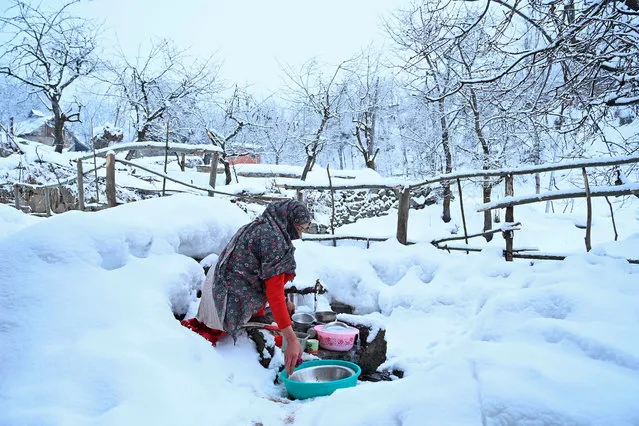 A woman washes utensils after a snowfall in the outskirts of Srinagar on January 29, 2020. (Photo by Tauseef Mustafa/AFP Photo)