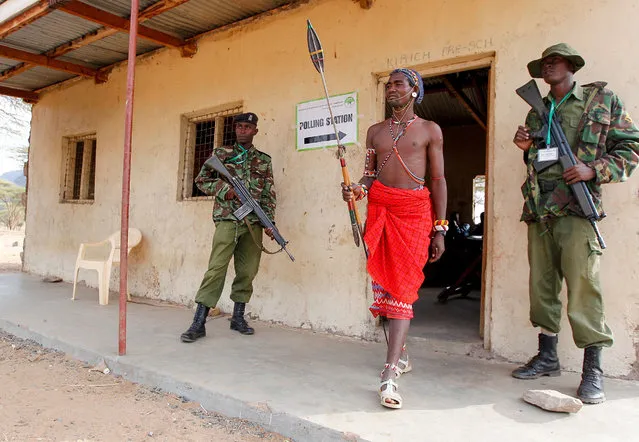 A Kenyan Samburu warrior leaves a polling station in Nkirish after voting in the general elections on August 8, 2017. Kenyans began voting in general elections headlined by a too-close-to-call battle between incumbent Uhuru Kenyatta and his rival Raila Odinga, sparking fears of violence in east Africa's richest economy. (Photo by Cyril Villemain/AFP Photo)