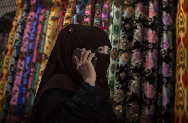 A Uyghur woman wears a veil as she shops at a local market on August 2, 2014 in Kashgar, Xinjiang Province, China. (Photo by Kevin Frayer/Getty Images)