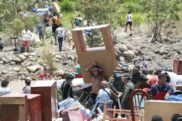 People carrying their belongings arrive in Colombia after crossing the Tachira river border with Venezuela, near Villa del Rosario village August 25, 2015. (Photo by Jose Miguel Gomez/Reuters)