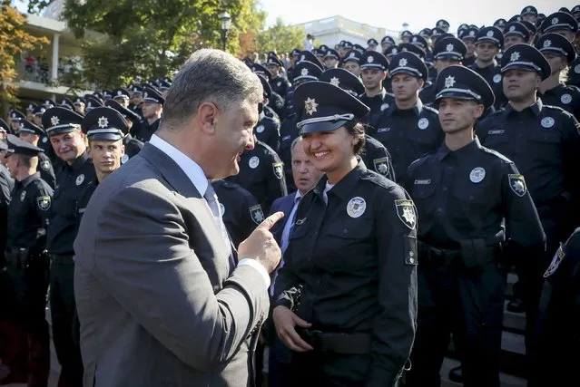 Ukrainian President Petro Poroshenko talks with a police officer during an oath-taking ceremony to launch the work of a new police patrol service, part of the Interior Ministry reform initiated by Ukrainian authorities, in Odessa, August 25, 2015, in this handout photo provided by the Ukrainian Presidential Press Service. (Photo by Markiv Mykhailo/Reuters/Ukrainian Presidential Press Service)