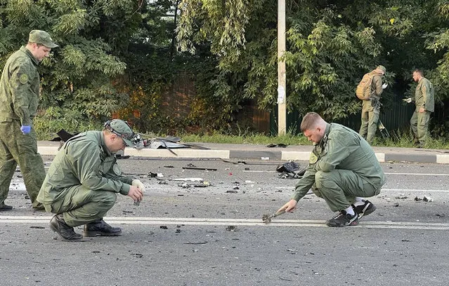 In this handout photo taken from video released by Investigative Committee of Russia on Sunday, August 21, 2022, investigators work on the site of explosion of a car driven by Daria Dugina outside Moscow. Daria Dugina, the daughter of Alexander Dugin, the Russian nationalist ideologist often called “Putin's brain”, was killed when her car exploded on the outskirts of Moscow, officials said Sunday. The Investigate Committee branch for the Moscow region said the Saturday night blast was caused by a bomb planted in the SUV driven by Daria Dugina.(Photo by Investigative Committee of Russia via AP)