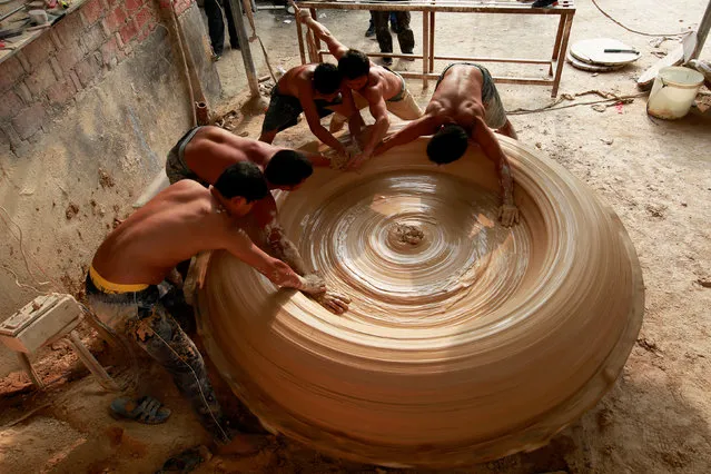 Workers make a vat at a porcelain factory in Jingdezhen, Jiangxi Province, China September 23, 2017. (Photo by Reuters/China Stringer Network)