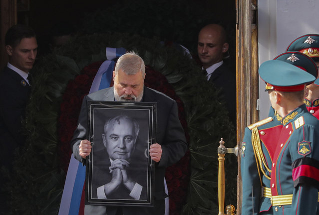 Nobel Peace Prize awarded journalist Dmitry Muratov carries a portrait of the late former Soviet president Mikhail Gorbachev after a farewell ceremony at the Pillar Hall of the House of the Unions in Moscow, Saturday, September 3, 2022. (Photo by Maxim Shipenkov/Pool Photo via AP Photo)