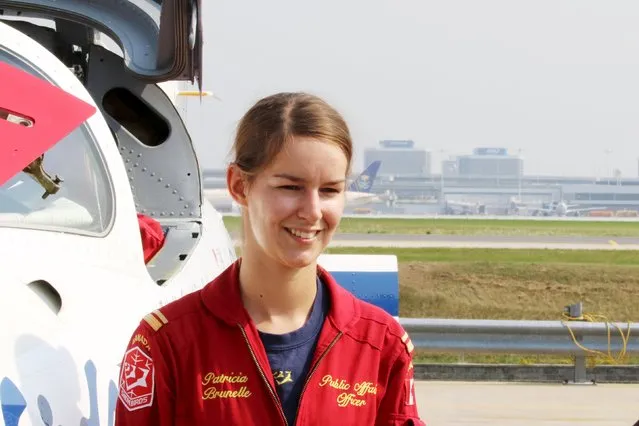Snowbird Pilot Lieutenant and Public Affairs Officer Patricia Brunelle smiles beside a Snowbird jet during media day for the Canadian International Air Show at Pearson Airport in Toronto, Ontario, September 3, 2015. (Photo by Louis Nastro/Reuters)