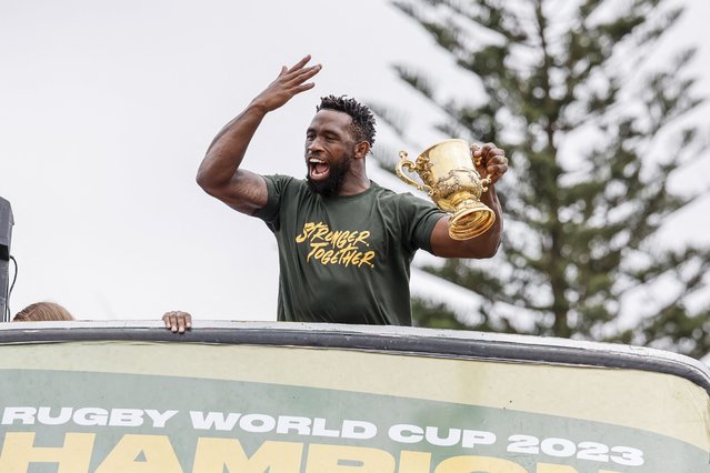 South Africa's flanker and captain Siya Kolisi reacts as he holds the throphy from the bus carrying the rest of the team during the Springboks Champions trophy tour in East London, South Africa, on November 5, 2023, after South Africa won the France 2023 Rugby World Cup final match against New Zealand. (Photo by Wikus De Wet/AFP Photo)