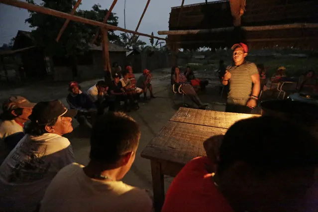 Ka'apor Indian warriors hold a meeting the night before they begin an operation to search for and expel loggers from the Alto Turiacu Indian territory, in the village of Waxiguy Renda near the Centro do Guilherme municipality in the northeast of Maranhao state in the Amazon basin, August 6, 2014. (Photo by Lunae Parracho/Reuters)