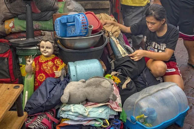 A statue of Baby Jesus is seen next to other retrieved belongings as a fire engulfs houses in a slum community on April 15, 2020 in Manila, Philippines. According to authorities, more than a hundred residents were rendered homeless after a fire razed the slum community, amid a government lockdown which has made the country's homeless vulnerable and in need of aid. Close to 70 percent of the homeless population are in Metro Manila and survive by begging, or collecting and reselling plastic and metal scraps. The Philippines' main island Luzon, which includes the capital Manila, remains on lockdown as authorities continue to struggle with the growing number of coronavirus, Covid-19 cases. Land, sea, and air travel has been suspended, while government work, schools, businesses, and public transportation have been ordered shut in a bid to keep some 55 million people at home. The Philippines' Department of Health has so far confirmed 5,223 cases of the coronavirus in the country, with at least 335 recorded fatalities. (Photo by Ezra Acayan/Getty Images)