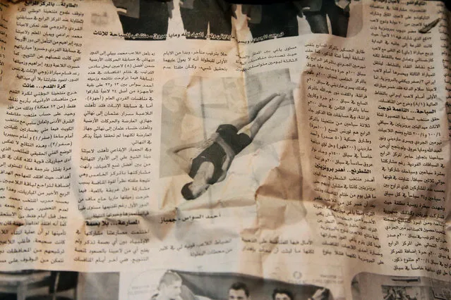 Gymnast Ahmad al-Sawas shows a picture in a newspaper, which he says was taken during his participation in the International Sports Games in the Sakha Republic in 2012, as his sits inside his home in the rebel-held Bustan al-Qasr neighbourhood of Aleppo, Syria March 23, 2016. (Photo by Abdalrhman Ismail/Reuters)