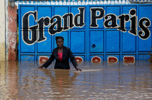 A trader, after securing the main entrance, walks from her premises after the River Nzoia burst its banks due to a backflow from Lake Victoria, in Nyadorera, Siaya County, Kenya on May 2, 2020. (Photo by Thomas Mukoya/Reuters)