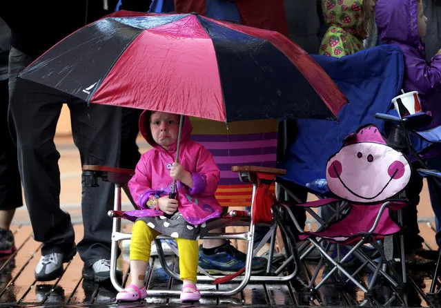 Paige Goodwin, 4, of Galloway, N.J., covers herself from the rain while waiting for the start of the Miss America Shoe Parade at the Atlantic City boardwalk, Saturday, September 13, 2014, in Atlantic City, N.J. (Photo by Julio Cortez/AP Photo)